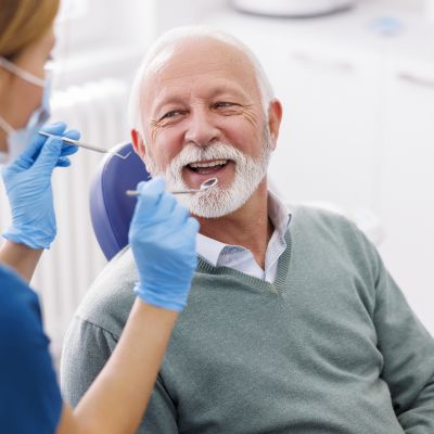 Doctor Checking Up Patient's Teeth At Dentist Office; Senior Man