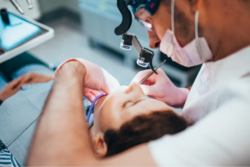 Dentist with patient in chair working on root canal retreatment